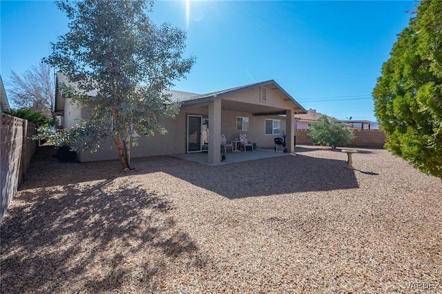 rear view of house with a patio area, a fenced backyard, and stucco siding