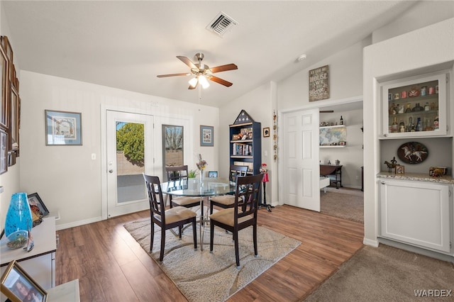 dining space featuring baseboards, ceiling fan, visible vents, and wood finished floors