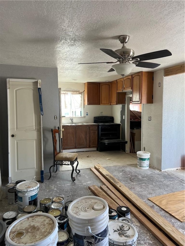 2495 E Devlin Ave, Kingman, AZ 86409 - kitchen with a textured ceiling, ceiling fan, brown cabinetry, black electric range, and a sink