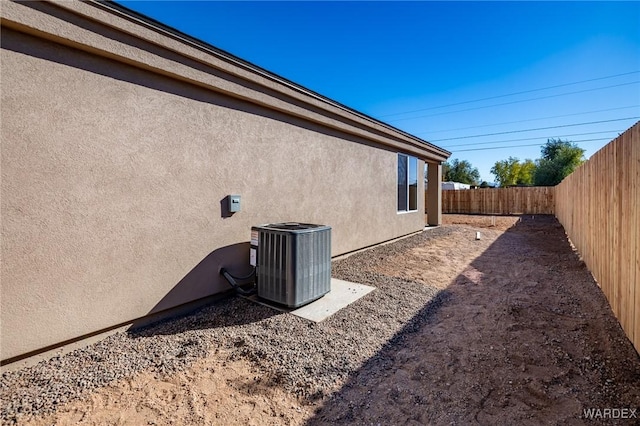 view of property exterior featuring a fenced backyard, cooling unit, and stucco siding