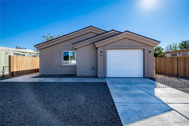 view of front of property with driveway, fence, an attached garage, and stucco siding