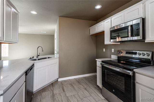 kitchen with appliances with stainless steel finishes, white cabinets, and light countertops