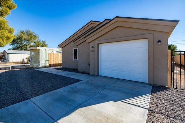 view of front of property featuring driveway, fence, and stucco siding