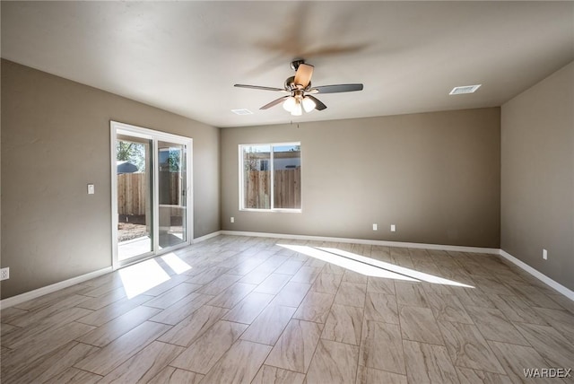 empty room featuring ceiling fan, light wood finished floors, visible vents, and baseboards