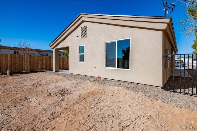 rear view of property with fence and stucco siding