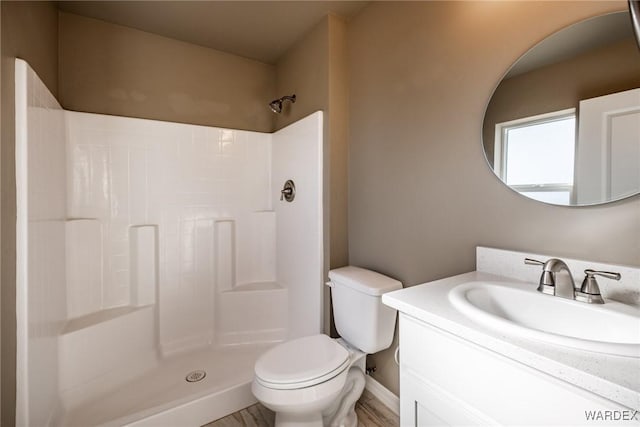 full bath featuring a stall shower, vanity, and toilet