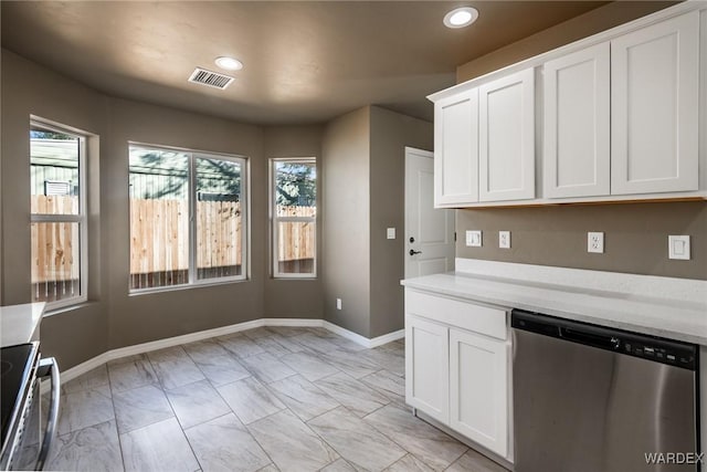 kitchen with appliances with stainless steel finishes, light countertops, visible vents, and white cabinetry