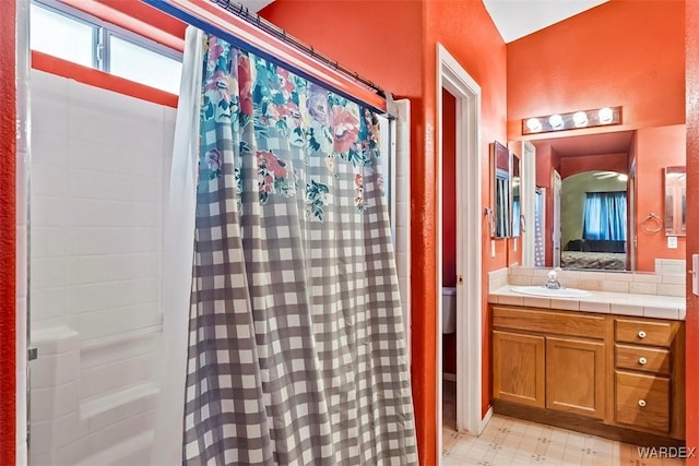 ensuite bathroom featuring curtained shower, tile patterned floors, vanity, and ensuite bathroom