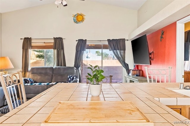 unfurnished dining area with high vaulted ceiling and ceiling fan