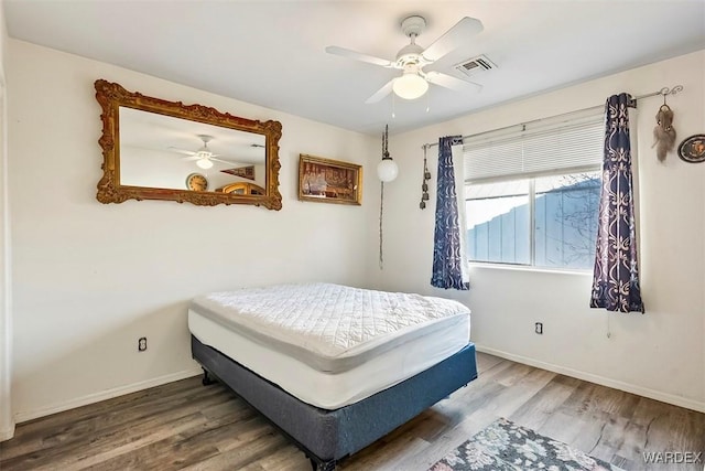 bedroom with visible vents, ceiling fan, baseboards, and wood finished floors