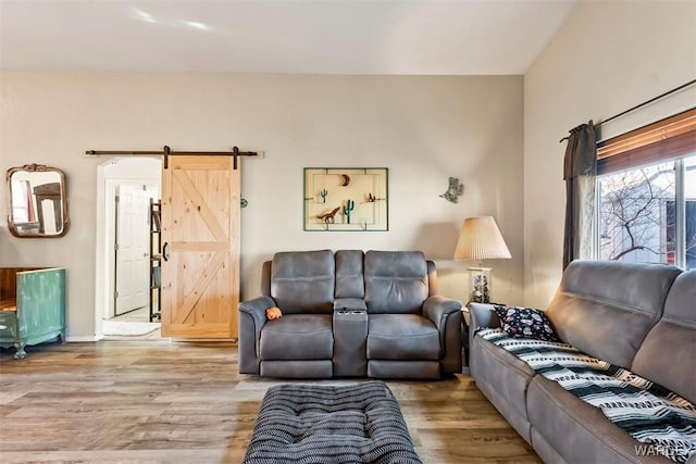 living area featuring a barn door and wood finished floors