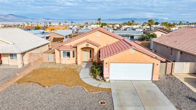 view of front of house with a residential view, stucco siding, concrete driveway, and a tile roof