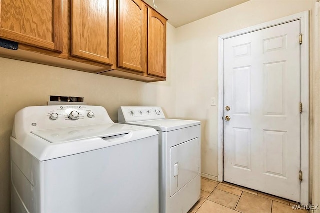 laundry room with light tile patterned flooring, cabinet space, and washing machine and clothes dryer