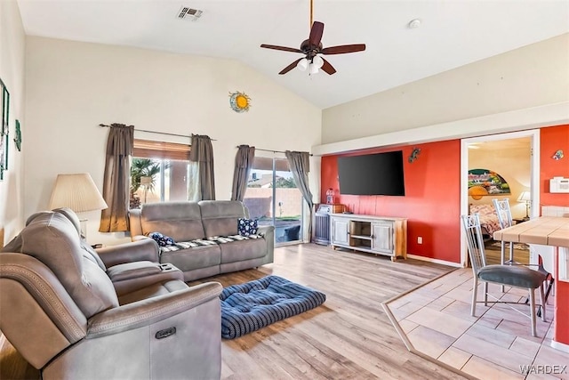 living room with visible vents, high vaulted ceiling, ceiling fan, and light wood-style flooring