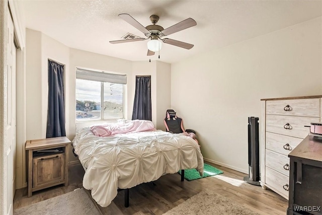 bedroom featuring visible vents, ceiling fan, baseboards, and light wood-style floors