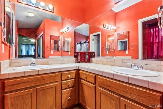 bathroom with ceiling fan, double vanity, and a sink