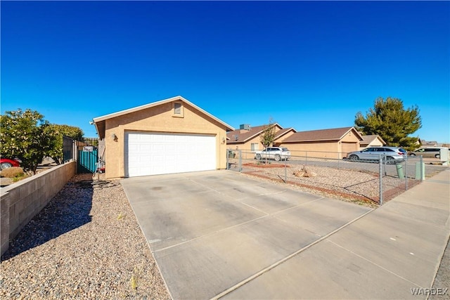 ranch-style house featuring a gate, fence, a garage, and stucco siding