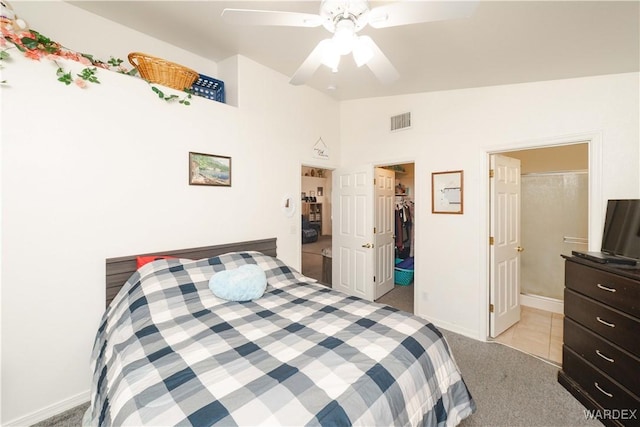 bedroom with visible vents, lofted ceiling, a closet, light carpet, and a walk in closet