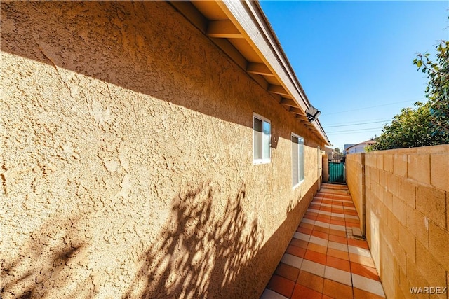 view of home's exterior featuring stucco siding and fence