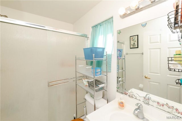 bathroom featuring a shower with shower door, toilet, and vanity