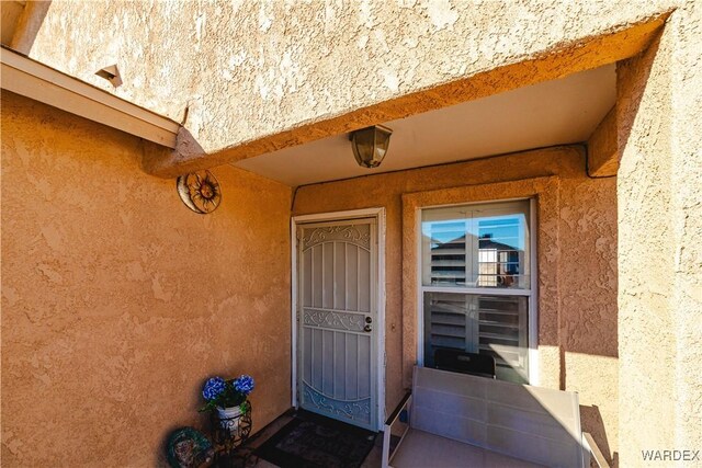 property entrance with stucco siding