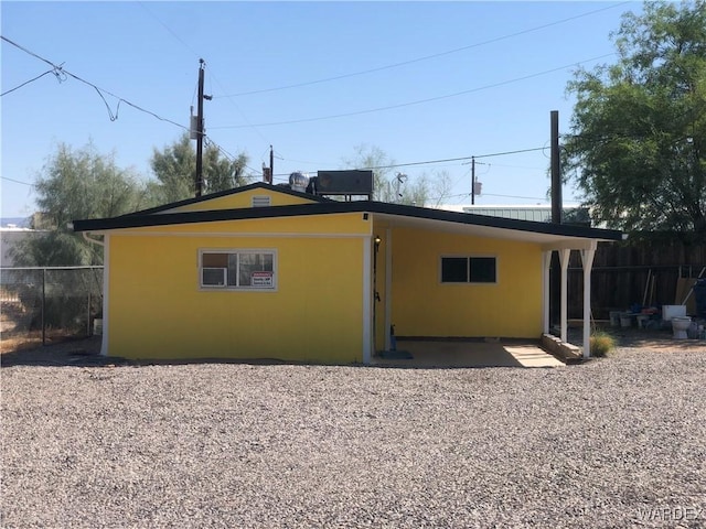 back of property with fence and stucco siding