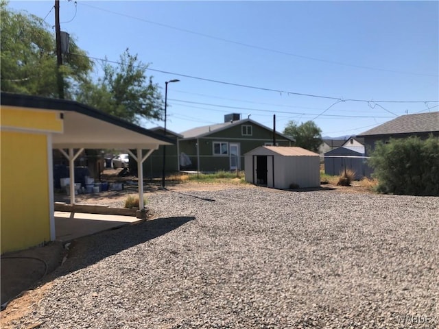 view of yard with an outbuilding, a storage shed, and fence