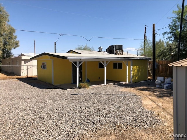 rear view of property with central air condition unit, fence, and stucco siding