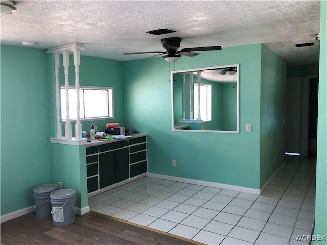 unfurnished room featuring a ceiling fan, visible vents, baseboards, and light tile patterned floors