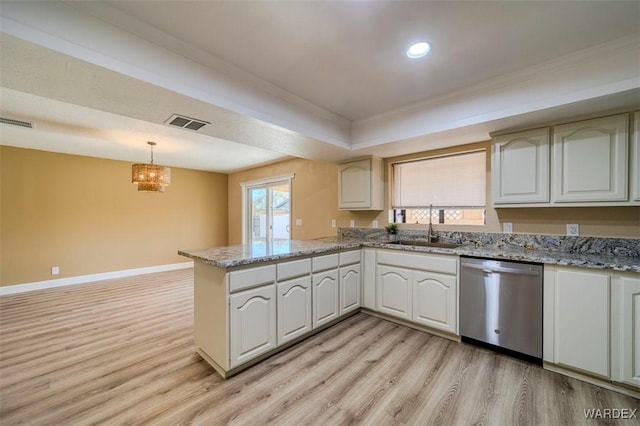 kitchen featuring a peninsula, a sink, visible vents, dishwasher, and decorative light fixtures