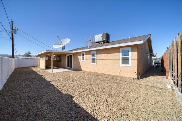 rear view of property featuring a patio area, a fenced backyard, cooling unit, and stucco siding