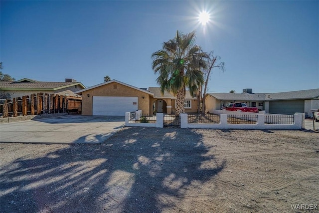 view of front of house featuring a garage, concrete driveway, a fenced front yard, and stucco siding