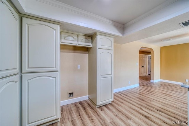 interior space featuring arched walkways, light wood finished floors, visible vents, and baseboards