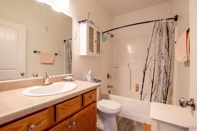 bathroom featuring toilet, shower / bathtub combination with curtain, wood finished floors, and vanity