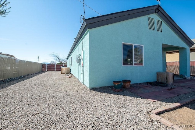 view of property exterior featuring a patio, a fenced backyard, and stucco siding