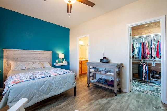 bedroom featuring light wood-type flooring, ceiling fan, a spacious closet, and a closet