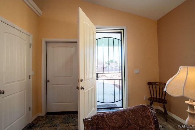 foyer entrance featuring lofted ceiling and baseboards