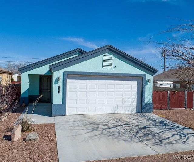 view of front facade featuring a garage, concrete driveway, fence, and stucco siding