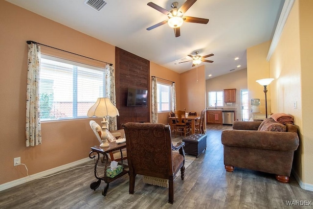 living area featuring visible vents, vaulted ceiling, baseboards, and wood finished floors