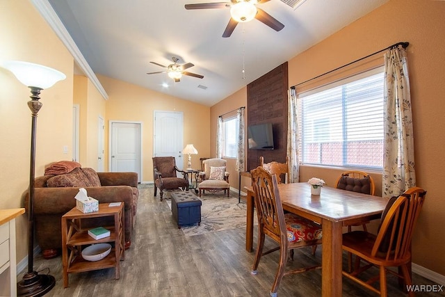 dining space with lofted ceiling, ceiling fan, wood finished floors, and baseboards