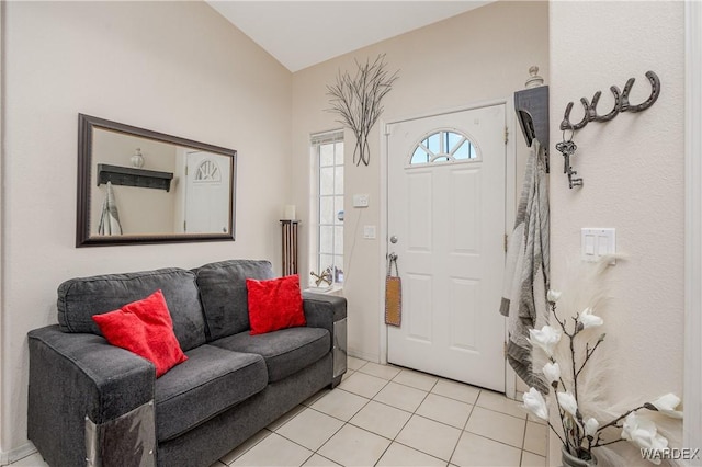 entrance foyer featuring lofted ceiling and light tile patterned flooring