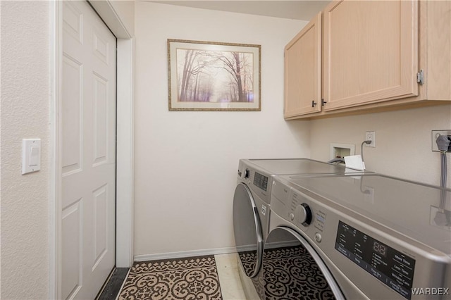 washroom with cabinet space, light tile patterned floors, baseboards, and washer and clothes dryer