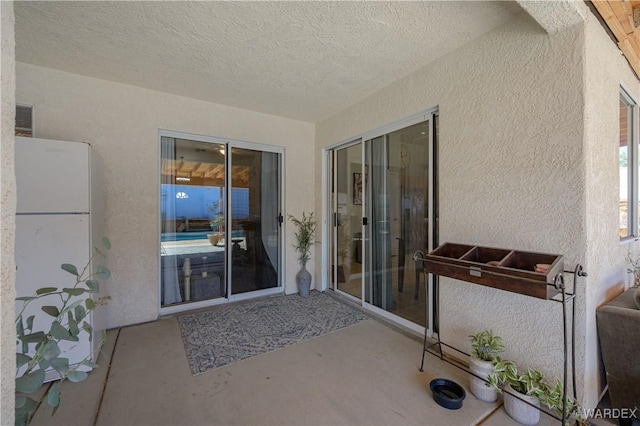 doorway to property with a patio area and stucco siding