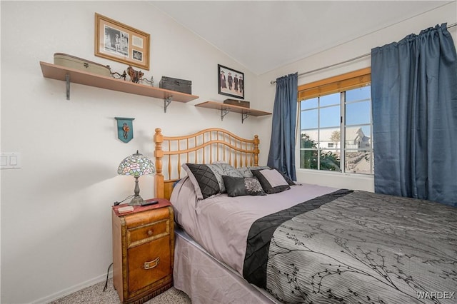 carpeted bedroom featuring vaulted ceiling and baseboards