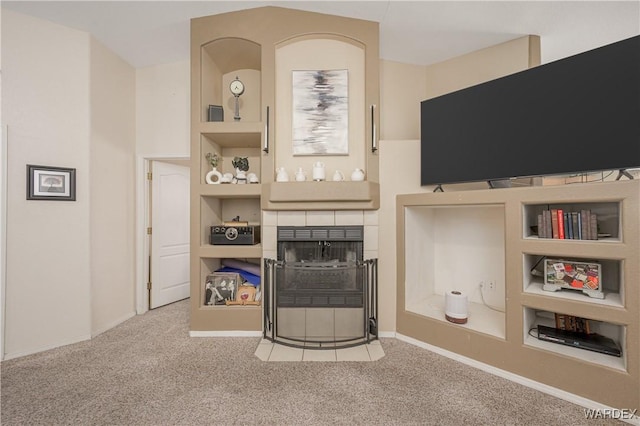 carpeted living room with baseboards, built in features, and a tiled fireplace