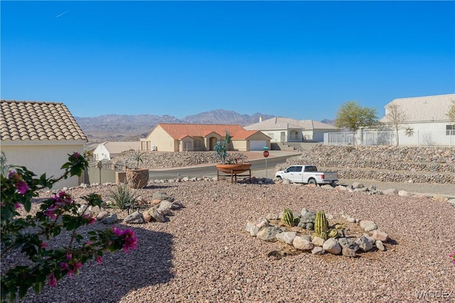 view of yard with a residential view, fence, and a mountain view