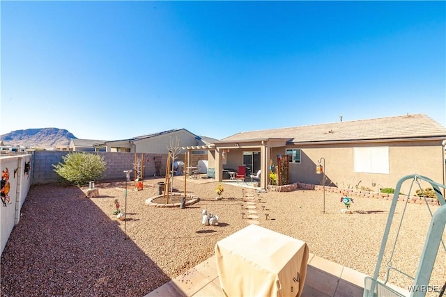 exterior space with a patio area, a fenced backyard, and stucco siding