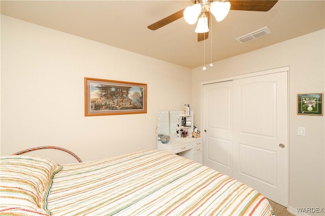 carpeted bedroom featuring a closet, visible vents, and ceiling fan