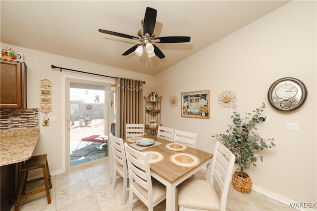 dining area with ceiling fan, baseboards, and vaulted ceiling