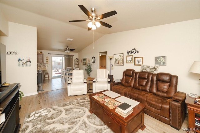 living room with light wood-style floors, ceiling fan, and vaulted ceiling